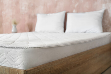 Fototapeta na wymiar Bed with comfortable orthopedic mattress in room