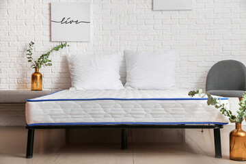 Bed with comfortable orthopedic mattress in room