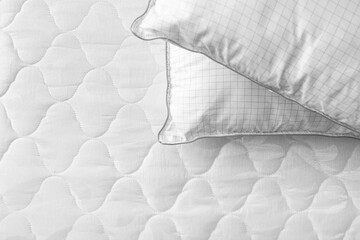 Modern orthopedic mattress with pillows on bed