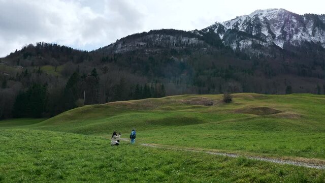 Mother Takes Pictures Photo on Smartphone of Little Child on Grass near Scenic Mountain Peak Stanserhorn. Ennetmoos Switzerland Europe