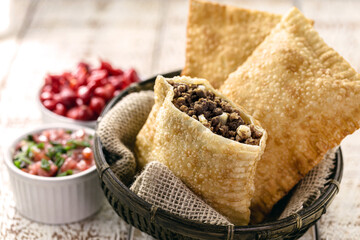 Brazilian pastry, fried and stuffed with ground meat and potatoes, hot sauce served hot.