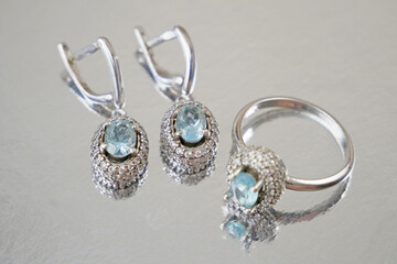 jewelry set with ring and earrings with blue topaz on silver background, pawnshop concept, jewerly...