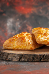 front view penovani khachapuri on oval wood board on dark red background