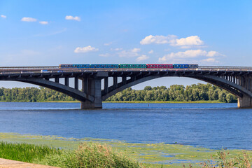 Fototapeta na wymiar View of Metro bridge with subway train passing and the Dnieper river in Kiev, Ukraine