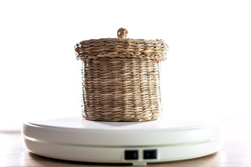 Close-up of a small wicker basket with a lid to leave things inside. White background.