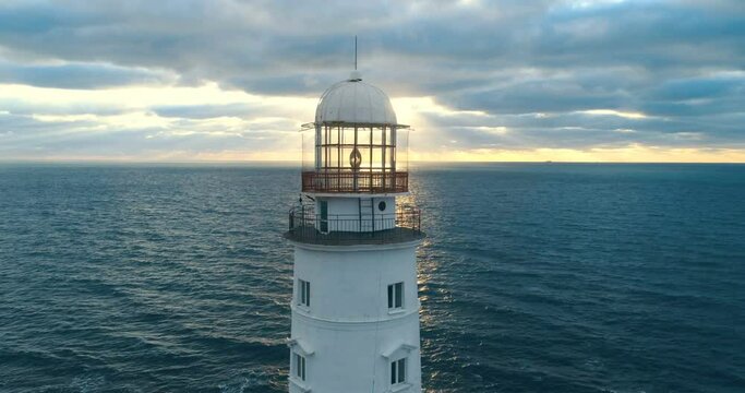 Picturesque white lighthouse at the sunset. 4k footage. Aerial view.