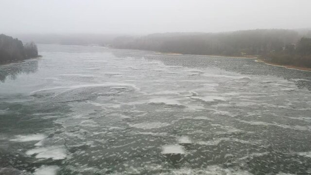 top view of an island in the middle of a frozen lake and fishermen catching fish