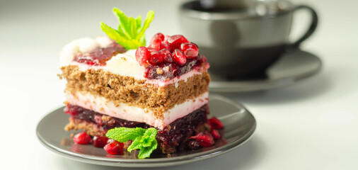 Colorful multi-layered cream chocolate cake with cherry jam and pomegranate