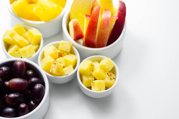 Various set fruits, pineapple, apple, grapes with matured cheddar cheese in bowls
