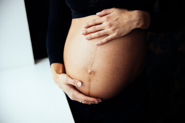 Close up photo shoot of pregnant bump with hands on it.