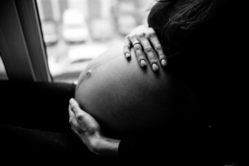 Close up photo shoot of pregnant bump with hands on it.