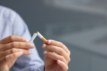 Close-up of man breaking cigarette on half.