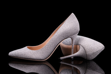 Silvery women shoes. High-heeled shoes. Silver heels. A pair of beautiful glitter shoes. Pumps.