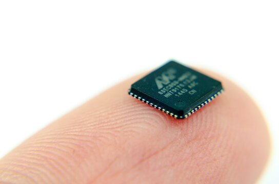Marvell Semiconductor chip placed on top of fingertip. Macro with the selective focus.