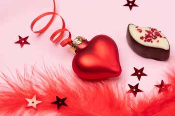 Valentine's day banner consisting of red glass hearts with fluffy pink feathers. Copy space for the text