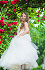Fototapeta premium Wonderful wedding dress. look as princess. bridesmaid. childhood happiness. girls party dress. female fashion salon. little beauty in blossoming garden. park jasmine flower. beautiful prom queen