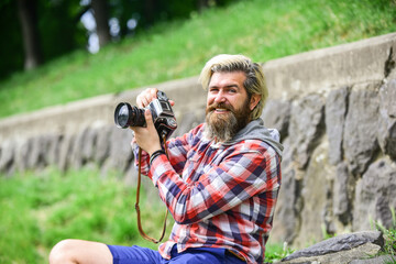 Content creator. Man bearded hipster photographer hold vintage camera. Photographer amateur photographer nature background. Masterpiece shot. Man with beard shooting photos. Photographer concept