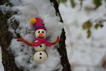 Snowman in a snowy forest. Christmas figurine close-up.