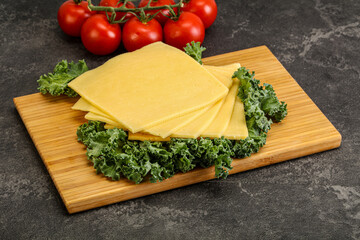 Sliced Gauda cheese over board