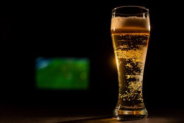 A pint of foaming lager and football on TV.
