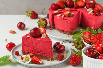 Raw vegan berry cheesecake with fresh strawberries, cherry and nuts. healthy vegan food