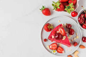 Raw vegan berry cheesecake gluten free and dairy free with fresh berries and nuts. Top view. Healthy vegan dessert