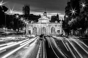 Obraz premium Night photo of Puerta de Alcala, neo-classical monument in the Plaza de la Independencia in Madrid, Spain in black and white.