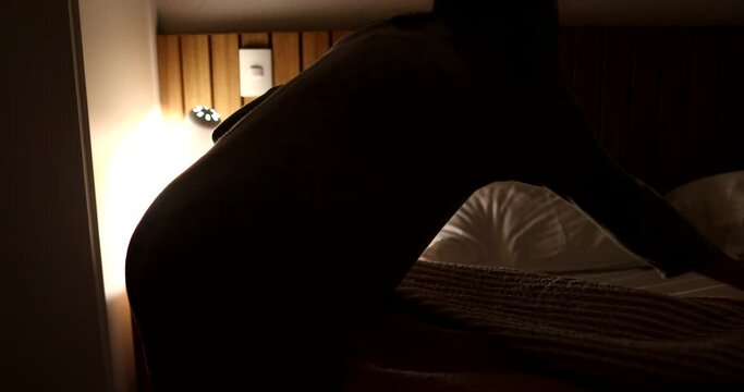 Woman making bed adjusting blanket, wpman tighting up bed