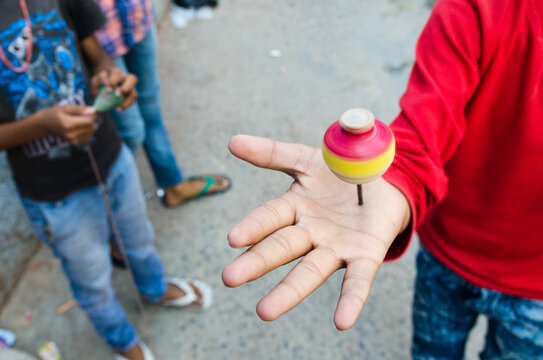 Young boy spinning a spinning top on his hand with motion blur, Jodhpur, India