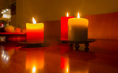 Burning candles and romantic candlelight on a shiny wooden table indoors, Almere, Flevoland, The Netherlands, December 20, 2020