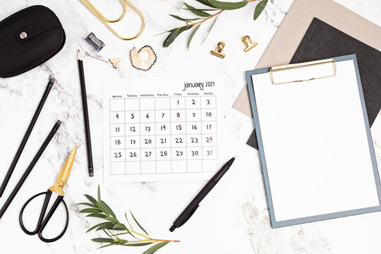 Desktop with calendar for january and office supplies. Home office, social media blog, schedule, planning concept. Flat lay, top view