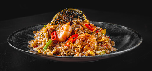 Fried rice with shrimp and vegetables in plate on wooden table background