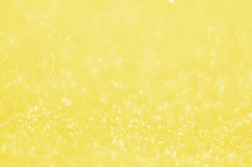 Illuminating Pantone Color Of The Year 2021. Abstract festive bokeh background with shining defocus sparkles. Blurred glitters shimmering dust macro close up, copy space for text logo