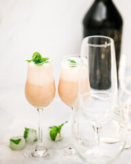 Cream liquor with frozen ice mint leaves close up in glasses on light background, vertical banner