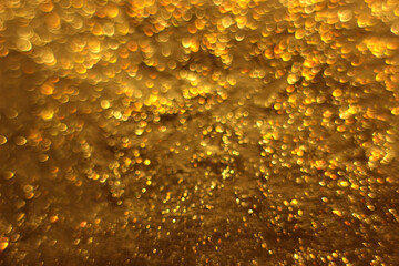 Blurred gold background. Glitter close-up.