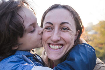 Boy kisses and hugs mom, happy motherhood