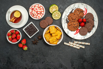 top view choco biscuits with candies and tea on dark background sweet cookie photo