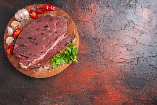 Overhead View Of Red Meat On Wooden Tray And Garlic Green Lemon Pepper Onion On Dark Background Footage