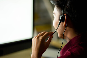 employee customer service representative working as technical support call center in the office with headphone computer overtime in the night
