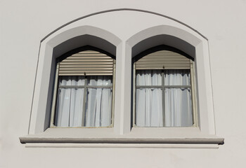 Colonial style windows with white curtains.