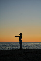 Fototapeta na wymiar young spanish girl doing exercise in front of the mediterranean sea at sunset