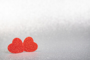 Fototapeta premium two red hearts in glitter on a silver glitter background