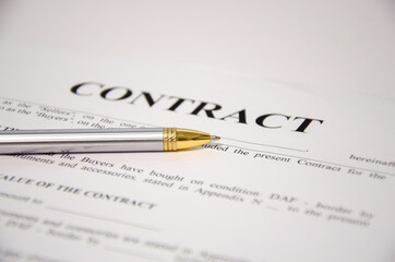 the pen is on the contract and the contract is on a white background