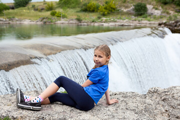 Portrait of pre-teen girl resting close to waterfall of the Cijevna river. It is called Montenegrin Niagara Falls. Surroundings of Podgorica city. Montenegro, Europe