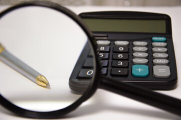 calculator and magnifier lie on a white background