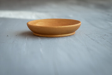 golden handmade painted wooden plate on grey background
