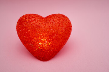 Red burning heart made of acrylic on a pink background. Lamp heart