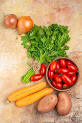 top view various fresh vegetables such as roma tomatoes potatoes onions carrot and a bunch of parsley for homemade salad on a wooden background with copy space