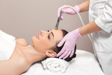 Obraz na płótnie Canvas The cosmetologist makes the procedure Microdermabrasion of the face skin of a beautiful girl in a beauty salon.Cosmetology and professional skin care.