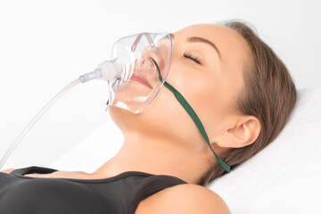 Young beautiful woman with oxygen mask in the hospital.